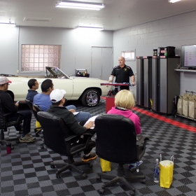 A detailing center with Free-Flow, a Chevy Malibu, and crew