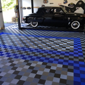 Classic car and lift in this garage with a custom designed floor with Racedeck Free Flow self draining garage floor tiles.