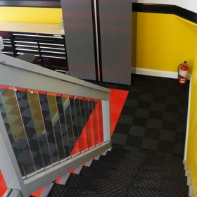 Racedeck Free Flow self draining floor tiles used as flooring in this garage and it continues on the stairs.