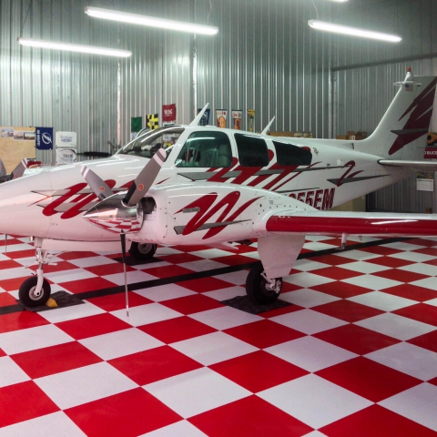 Red and white checkered RaceDeck Diamond flooring for a red and white plane.
