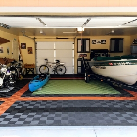 Free-Flow self-draining garage floor tiles in graphite, black, orange and light green. The perfect choice for this outdoor enthusiasts' garage.