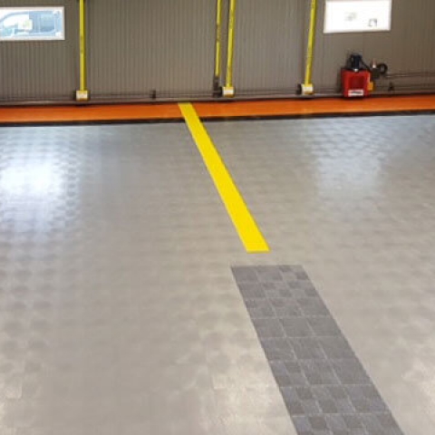View inside a hangar with RaceDeck Diamond flooring in multiple colors.