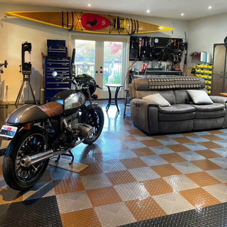 BMW and Motorcycle parked in this multipurpose TuffShield garage and lounge area.