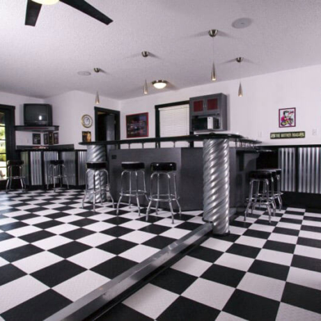 Game room and bar area with RaceDeck Diamond black and white checkered flooring.