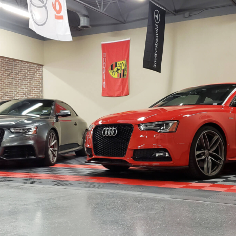 Two Audis on a Free-Flow parking pad in a commercial garage