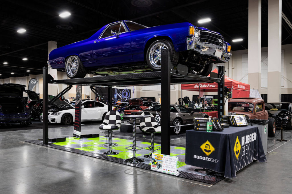 A RaceDeck display floor with a four post lift and an El Camino. The display features RaceDeck Diamond with TuffShield garage floor tiles.