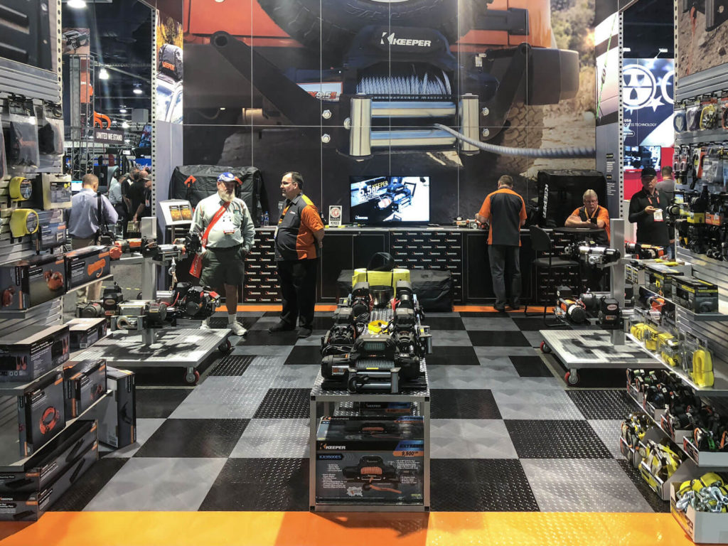 Keeper booth at SEMA with RaceDeck's TuffShield flooring in black, alloy, and orange