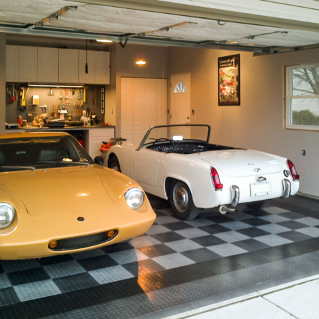 A garage with CircleTrac flooring, a vintage Lotus and and a vintage MG Midget