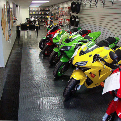 Shop with motorcycles lined up on RaceDeck graphite and black flooring.