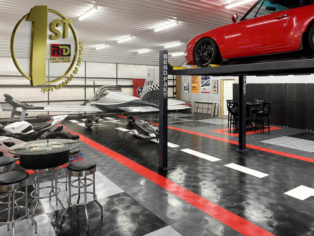 Paul Straub's garage and airplane hangar with multiple rides, a lift, and floored with RaceDeck Diamond.