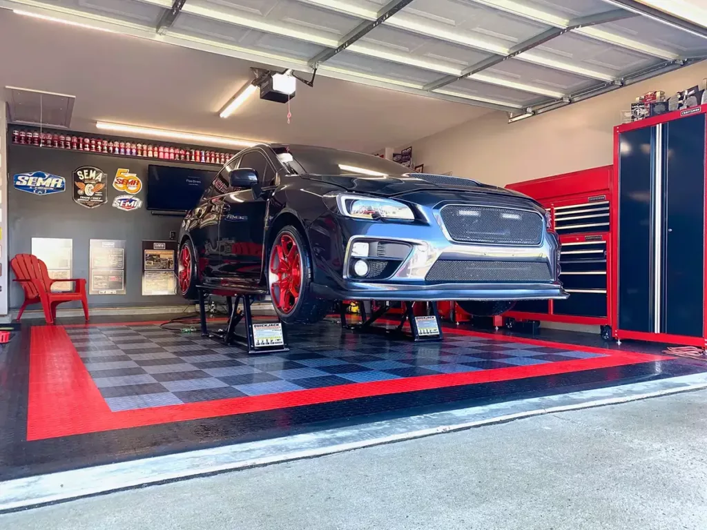 Alloy, Graphite, Red, & Black Circletrac with sedan on lift