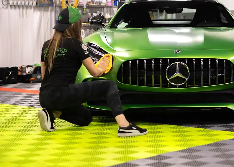 A detailer at Sweet Ride details a Mercedes on a RaceDeck Floor.