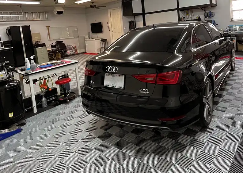 A window tinter's shop with a black Audi and a Free-Flow floor.