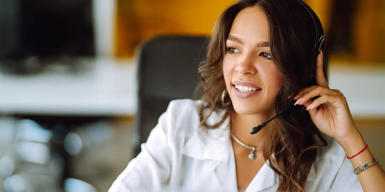 A customer service representative take a call on her headset