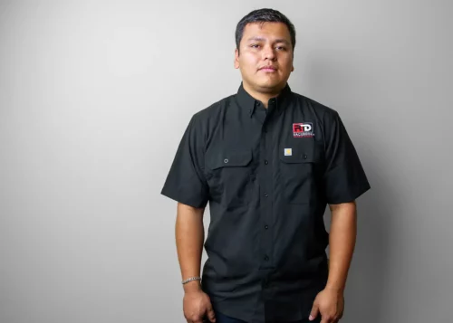 Model wearing a black short sleeve shirt with an embroidered RaceDeck Logo