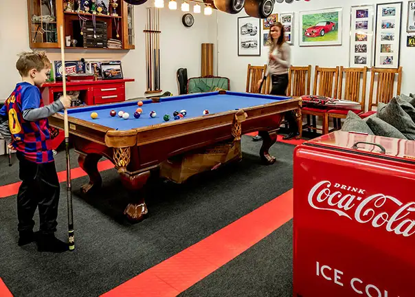 Mother and son play pool in a room with Snap-Carpet