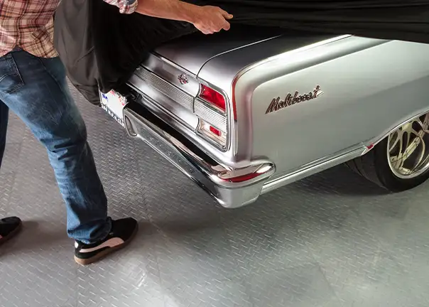 An old man uncovers his Chevy Malibu on TuffShield tiles