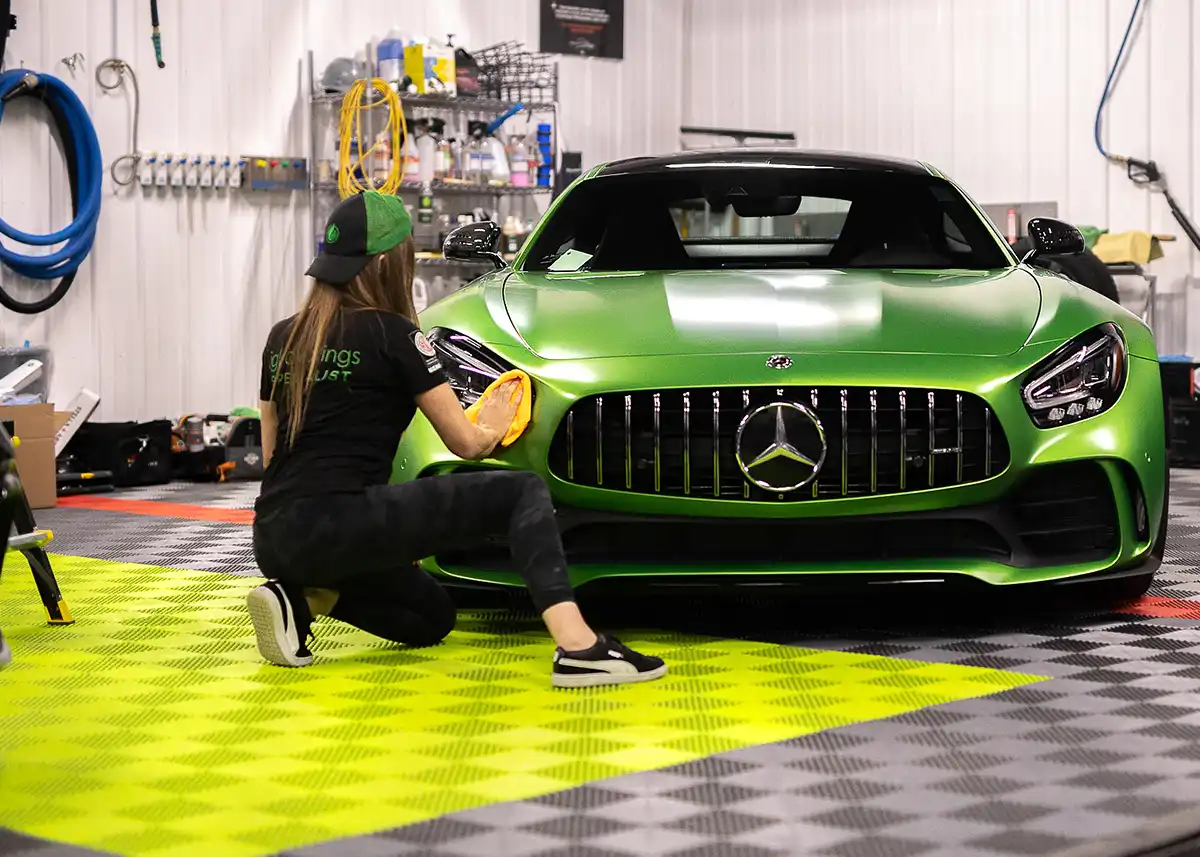 A woman details a Mercedes-Benz in a wash bay with Free-Flow