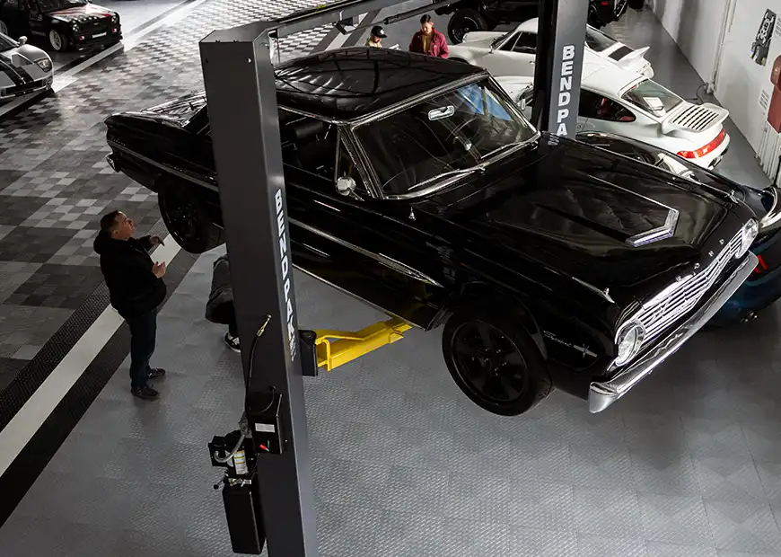 A car on lift in a shop with RaceDeck commercial flooring