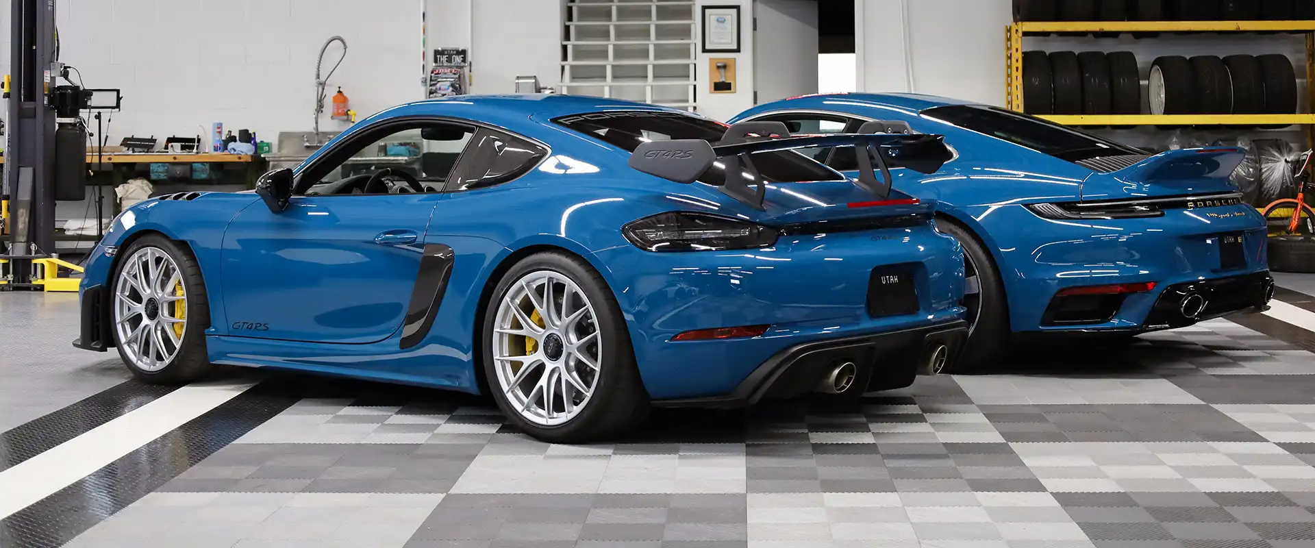 two blue Porsches in a speed shop with RaceDeck Commercial flooring