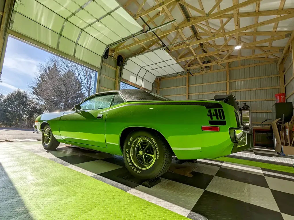 RaceDeck Diamond Garage Floor Tiles with a green car parked on it