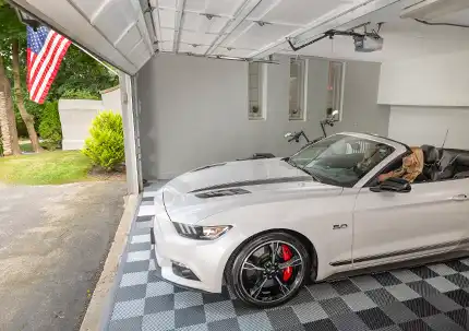 A two woman pull a mustang out of a garage with Free-Flow flooring.